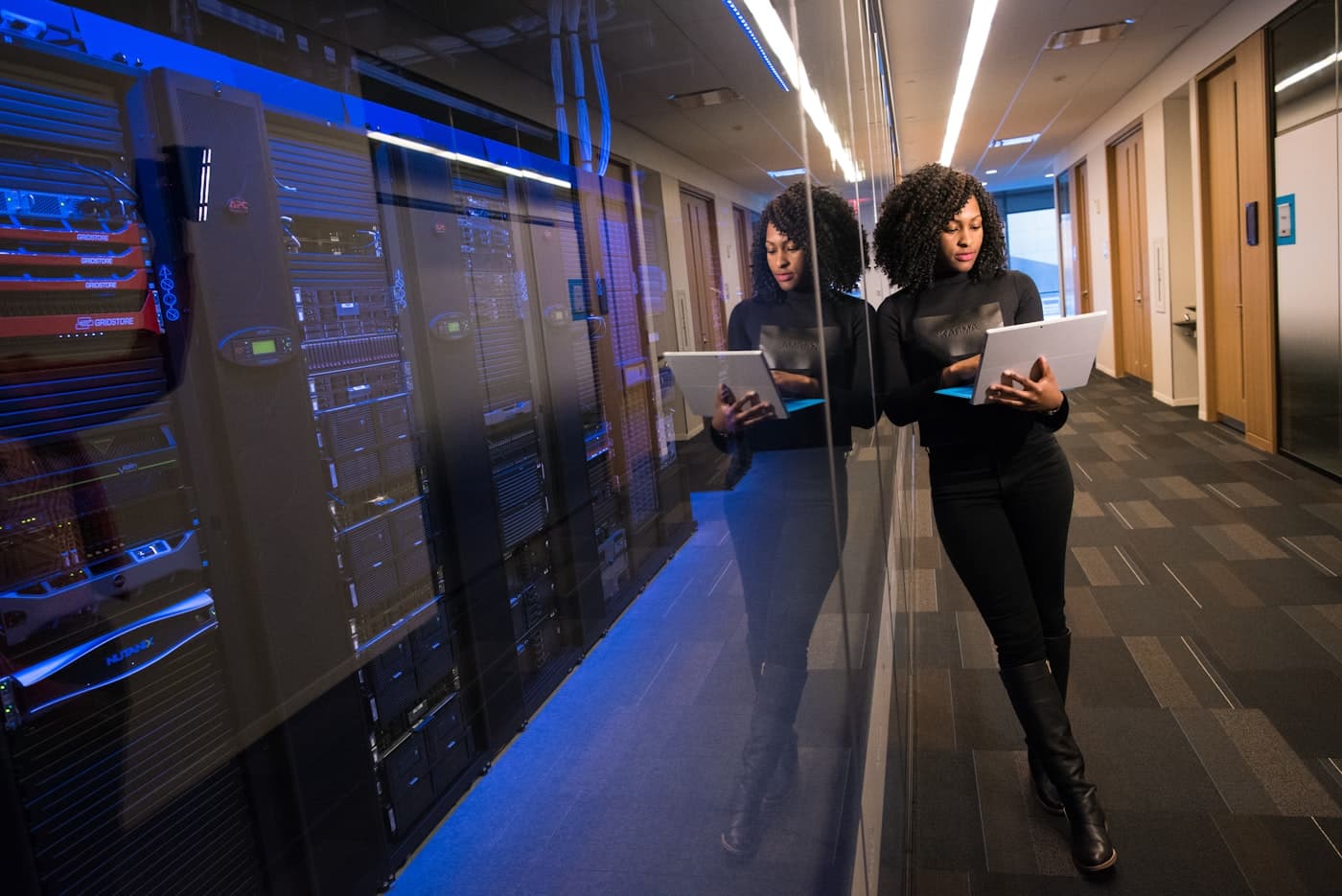 A screening analyst reviewing results on a laptop beside secure data centre racks